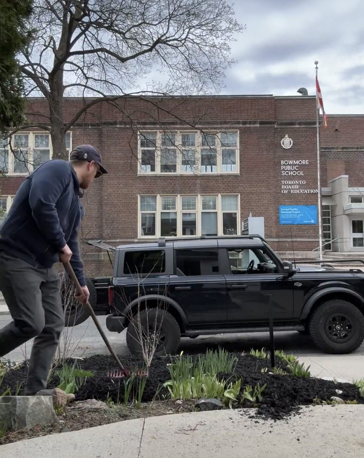 J.J. McCarthy raking and planting a community garden bed in front of Bowmore Public School in Toronto
